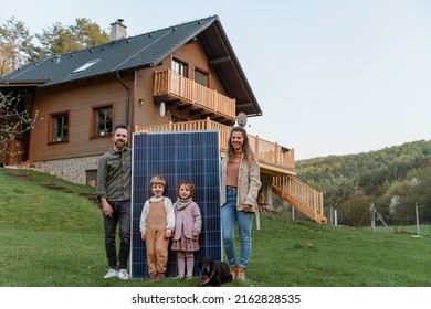 Happy Family Near Their House With Solar Panels. Alternative Energy Source