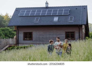 Happy family near their house with solar panels. Alternative energy, saving resources and sustainable lifestyle concept. - Shutterstock ID 2316236835