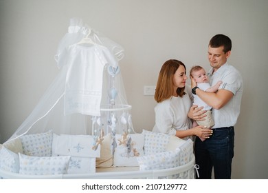 A Happy Family With A Newborn Baby At Home Near The Cot. Mom, Dad And Baby. Psychological Assistance To Parents. Products And Cosmetics For The Whole Family. Foster Family And Adoption Of Children.