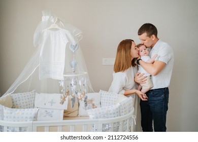 A Happy Family With A Newborn Baby At Home Near The Cot. Mom, Dad And Baby. Psychological Assistance To Parents. Products And Cosmetics For The Whole Family. Foster Family And Adoption Of Children.