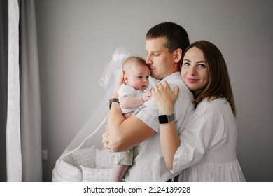 A Happy Family With A Newborn Baby At Home Near The Cot. Mom, Dad And Baby. Psychological Assistance To Parents. Products And Cosmetics For The Whole Family. Foster Family And Adoption Of Children.