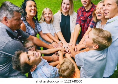 Happy family with nine children heaping hands