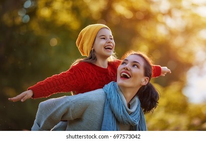 Happy family on autumn walk! Mother and daughter walking in the Park and enjoying the beautiful autumn nature. - Powered by Shutterstock