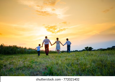 Happy Family On The Background Of The Sunset