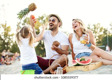 Happy Family On The Beach Enjoying Picnic.