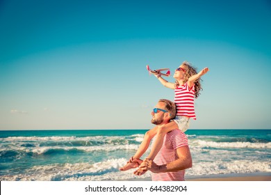 Happy family on the beach. People having fun on summer vacation. Father and child against blue sea and sky background. Holiday travel concept - Powered by Shutterstock