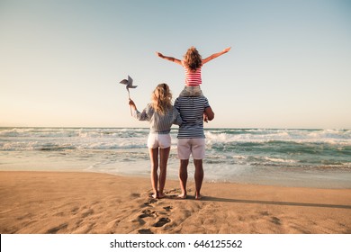 Happy family on the beach. People having fun on summer vacation. Father, mother and child against blue sea and sky background. Holiday travel concept - Powered by Shutterstock