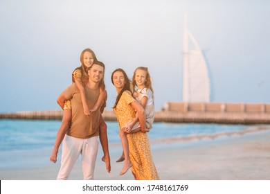 Happy Family On The Beach At Summer Vacation In Dubai, UAE. United Arab Emirates Famous Tourist Destination.