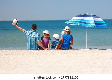 Happy Family On The Beach With Umbrella