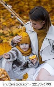 Happy Family On A Beautiful Fall Picnic In The Park. Cozy Autumn Vibes. Young Mother And Her Cute Son Spending Quality Time Together, Having Fun In The Park 