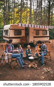 Happy Family On A Camping Trip Relaxing In The Autumn Forest. Camper Trailer. Fall Season Outdoors Trip