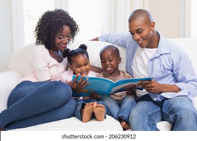 Happy family on the couch reading storybook at home in the living room