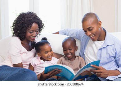 Happy family on the couch reading storybook at home in the living room