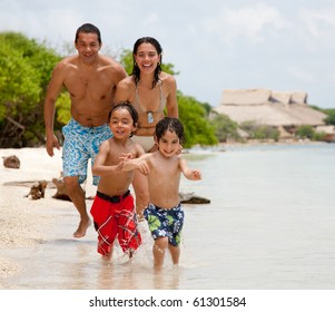 Happy Family On Holidays Playing At The Beach