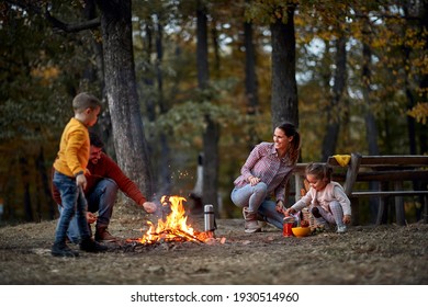 Happy Family On Picnic In Forest Near Campfire