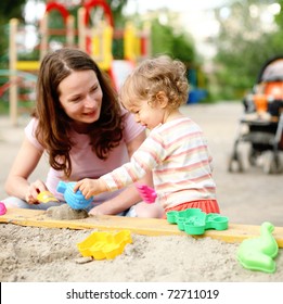 Happy Family On Playground In Summer