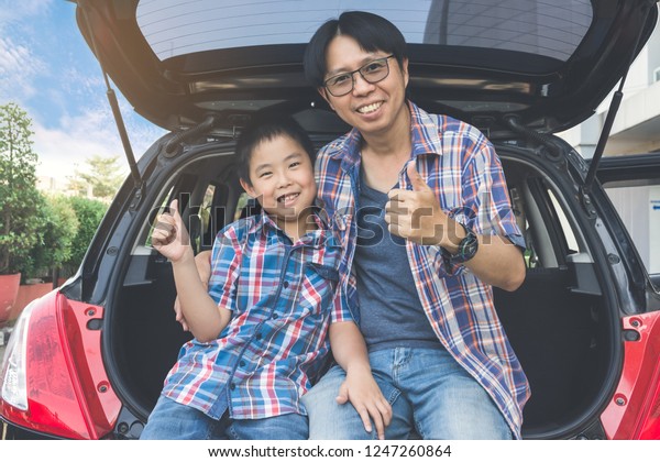 Happy\
family on a road trip, Sitting In Trunk Of\
Car