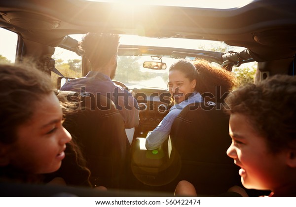 Happy family on a road trip in their car, rear\
passenger POV