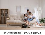 Happy family on sofa and puppy in living room