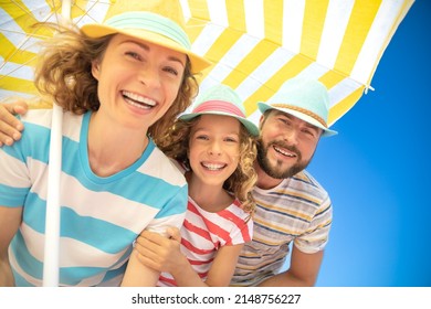 Happy Family On Summer Vacation. Low Angle View Portrait Of Happy People Against Blue Sky Background