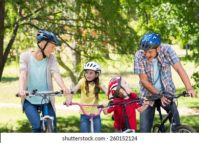 Happy Family On Their Bike At The Park On A Sunny Day