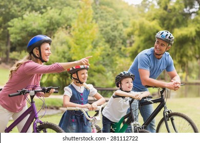 Happy Family On Their Bike At The Park On A Sunny Day