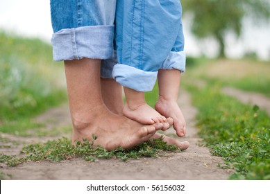 Happy Family on a Walk in Summer. Child with Father Together. Feet Barefoot on Green Grass. Healthy Lifestyle. Dad and Son. Spring Time.