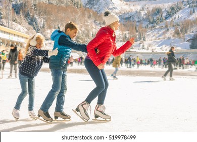 Happy Family Outdoor Ice Skating At Rink. Winter Activities