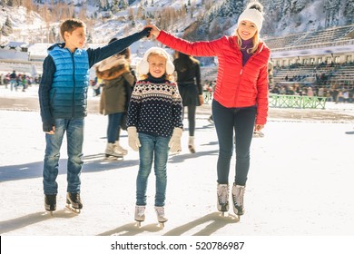 Happy Family Outdoor Ice Skating At Rink. Winter Activities