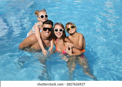 Happy family in outdoor swimming pool on sunny summer day - Powered by Shutterstock