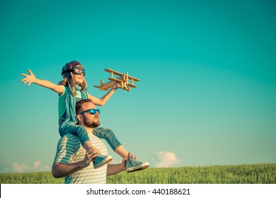 Happy Family Outdoors. Child Playing With Father. Dad And Son Having Fun In Summer Field. Man Carrying Kid. Child With Toy Airplane. Kid Pretend To Be Pilot. Travel, Vacation And Freedom Concept