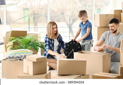 Happy family packing boxes in room. Moving concept
