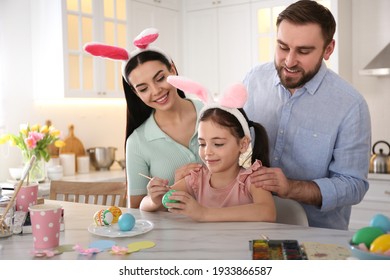 Happy Family Painting Easter Eggs At Table In Kitchen