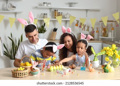 Happy Family Painting Easter Eggs In Kitchen