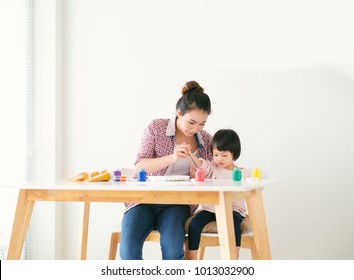 A Happy Family Is Painting. Mom Help Her Daughter Drawing