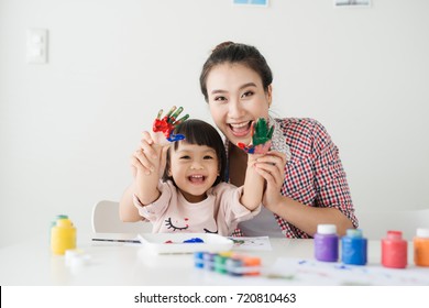 A Happy Family Is Painting. Mom Help Her Daughter Drawing