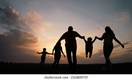 happy family. parent a baby together run in the park at sunset silhouette. people in the park concept. mom dad daughter and son joyful run. happy family and baby child summer kid dream concept fun - Powered by Shutterstock