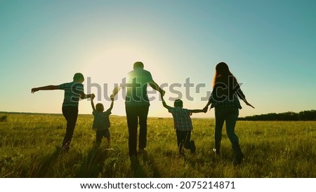 Happy family, parents, children run in the park. The concept of a big happy family. Family walk, silhouette of parents and children at sunset. Mom dad, sons walk together. Family vacation, dreams