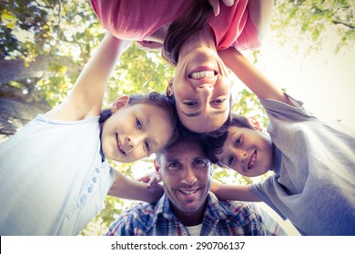 Happy Family In The Park Huddling In Circle On A Sunny Day