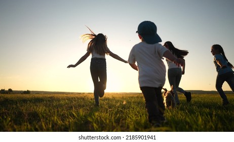 Happy Family. People In The Park. Children Child Running Together In The Park On The Grass Silhouette. Daughter And Son Are Running. Happy Family And Little Child In Summer. Concept Sunset Dream