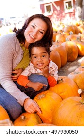 Happy Family Picking Pumpkins At The Pumpkin Patch.