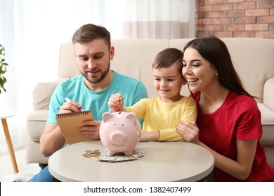 Happy Family With Piggy Bank And Money At Home