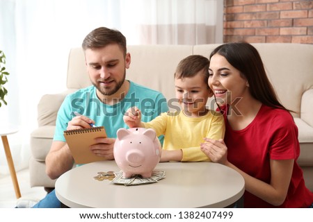 Happy family with piggy bank and money at home