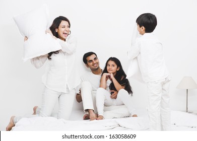 Happy Family Pillow Fight On The Bed