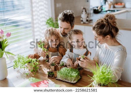 Happy family planting herbs together at spring.