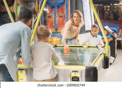 Happy Family Playing Air Hockey Together In Entertainment Center  