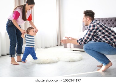 Happy Family Playing And Baby Learning To Walk At Home