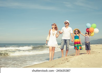 Happy family playing  with balloons on the beach at the day time. Concept of friendly family.