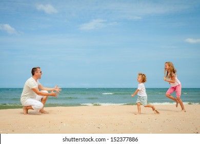 Happy Family Playing At The Beach In The Day Time