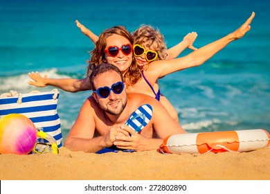 Happy Family Playing At The Beach. Summer Vacation Concept